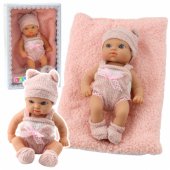 Kūdikio lėlė su antklode, baltais ir rožiniais drabužiais, kepuraite, 18 cm